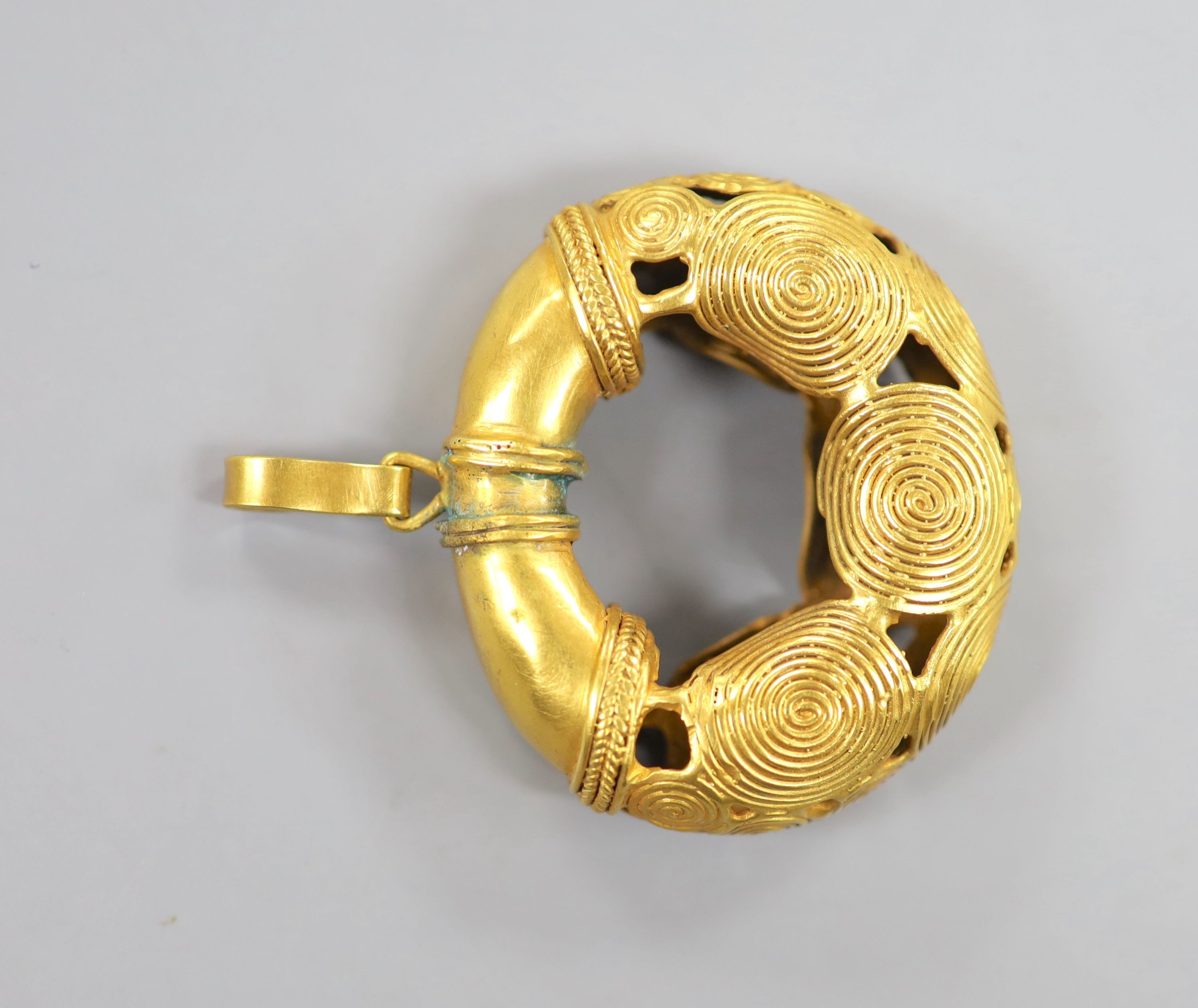 An Indian? pierced gilt metal pendant, 5cm.
